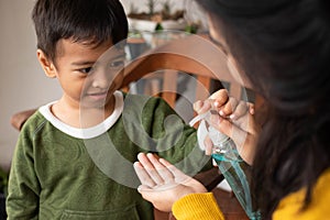 A mother uses antiseptics for her son at home