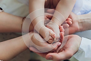 Mother uses her hand to hold her baby& x27;s tiny hand to make him feeling her love, warm and secure.