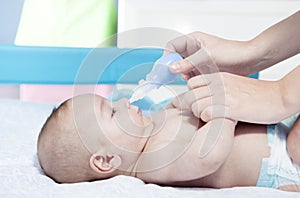 Mother using baby nasal aspirator photo