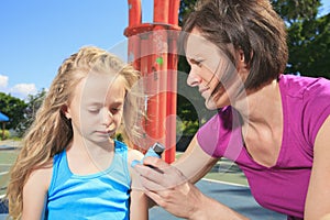 Mother using inhaler with her asthmatic daughter photo