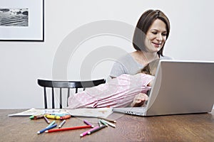 Mother using laptop being disturbed by daughter (3-4)