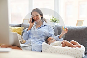 Mother using raffle for baby while talking to client on phone