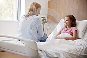 Mother Visiting Daughter Lying In Bed In Hospital Ward