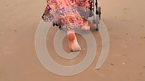Mother walking on beach with stroller