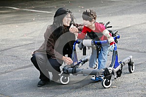 Mother walking with disabled son in walker