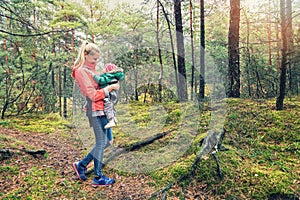 Mother walking in the woods with baby in kangaroo bag