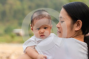 Happy baby girl and mother in outdoor and look at camera photo