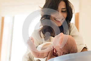 Mother washing baby in bath tub