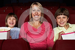 Mother Watching Film In Cinema With Two Children