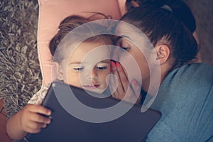 Mother whispered to her daughter on ear and using iPod. photo