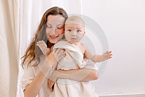 Mother in white clothes kiss a baby. Purity innocence sanctity of motherhood.