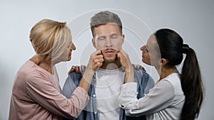 Mother and wife admiring mature man and pinching cheeks, overprotection