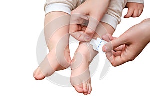 Mother woman sticks a medical adhesive plaster on the toddler baby l