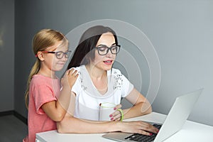 Mother working from home with little daughter