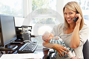 Mother working in home office with baby