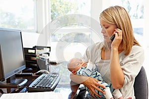 Mother working in home office with baby