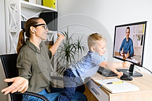 Mother works in home office with kid on laps