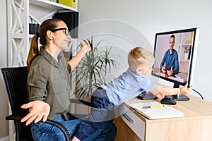 Mother works in home office with kid on laps