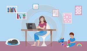 Mother works at home remotely with laptop. Baby toddler playing with toys on floor. Young woman working and sitting at table. Cat