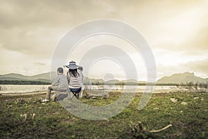 Mother with young daughters and son on picnic near the lake