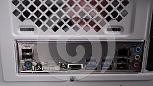 Motherboard connectors are inserted into holes of white case.