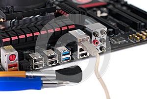 Motherboard with a network cable connected to it and tools for repair