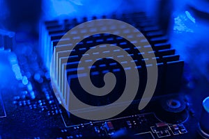 Motherboard radiator with blue backlight. Electronics in neon light