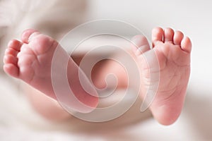 Mothercare newborn concept. Mother holding baby feet photo