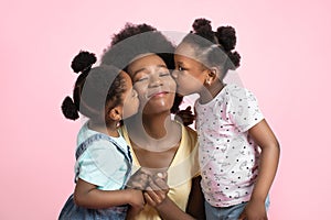 Motherhood and family concept. Lovely cute two little African girls kids in summer outfits, having fun and kissing their