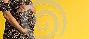 Motherhood, femininity, love, care, waiting, hot summer - bright banner Close-up unrecognizable pregnant woman in floral