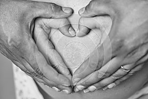 Motherhood. Hands make heart on belly