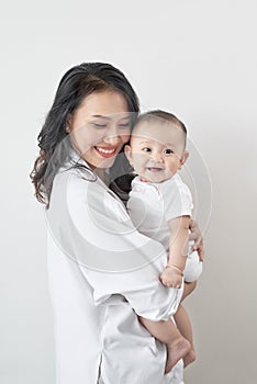 Motherhood and lifestyle concept. Smiling young mother with little baby at home