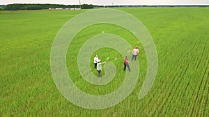 Mothers blow bubbles on a green field, children catch them.