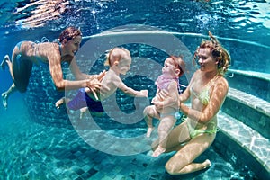 Mothers with children swim underwater in blue beach pool