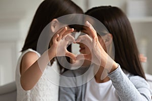 Mothers and daughters fingers showing heart symbol of love