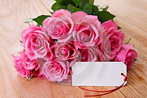 Mothers day background with pink roses over wooden table.