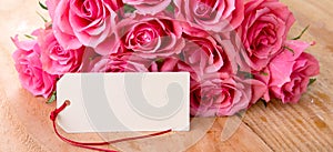 Mothers day background with pink roses over wooden table.