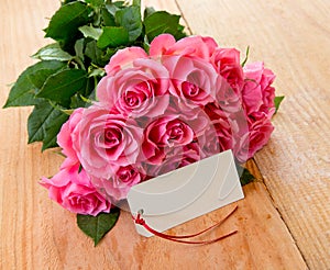 Mothers day background with pink roses over wooden table.