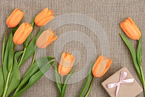 Mothers Day background. Tulips, gift on sackcloth