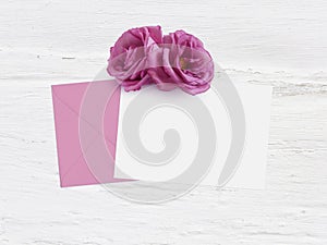 Mothers day, birthday or wedding mockup scene with envelope, blank card and rose flowers. Grunge white background, flat