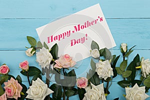 Mothers day card and beautiful roses on blue wooden background