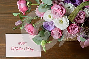 Mothers day card. Bouquet of pink roses in basket on wooden background closeup