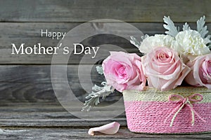 Mothers Day card. Pink roses in basket on wooden background