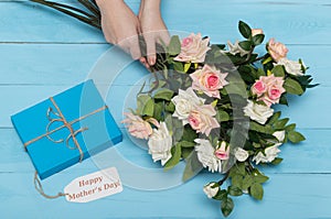 Mothers day card and roses on blue background with gift
