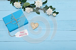 Mothers day card and roses on blue background with gift