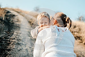 Mothers Day, celebrates motherhood, holiday in honor of mothers. Little boy kid son runing into the arms of his mother