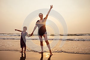 Mothers Day concept of love, parenthood and a happy family. Mother and child daughter having fun at sunset on beach