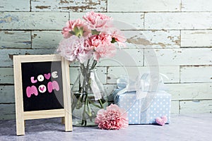 Mothers day concept of pink carnation flowers in clear bottle an