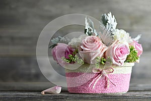 Mothers Day flowers. Pink roses in basket on wooden background