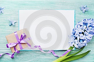 Mothers Day holiday card with empty notebook for greeting text, gift or present box and fresh flowers top view.